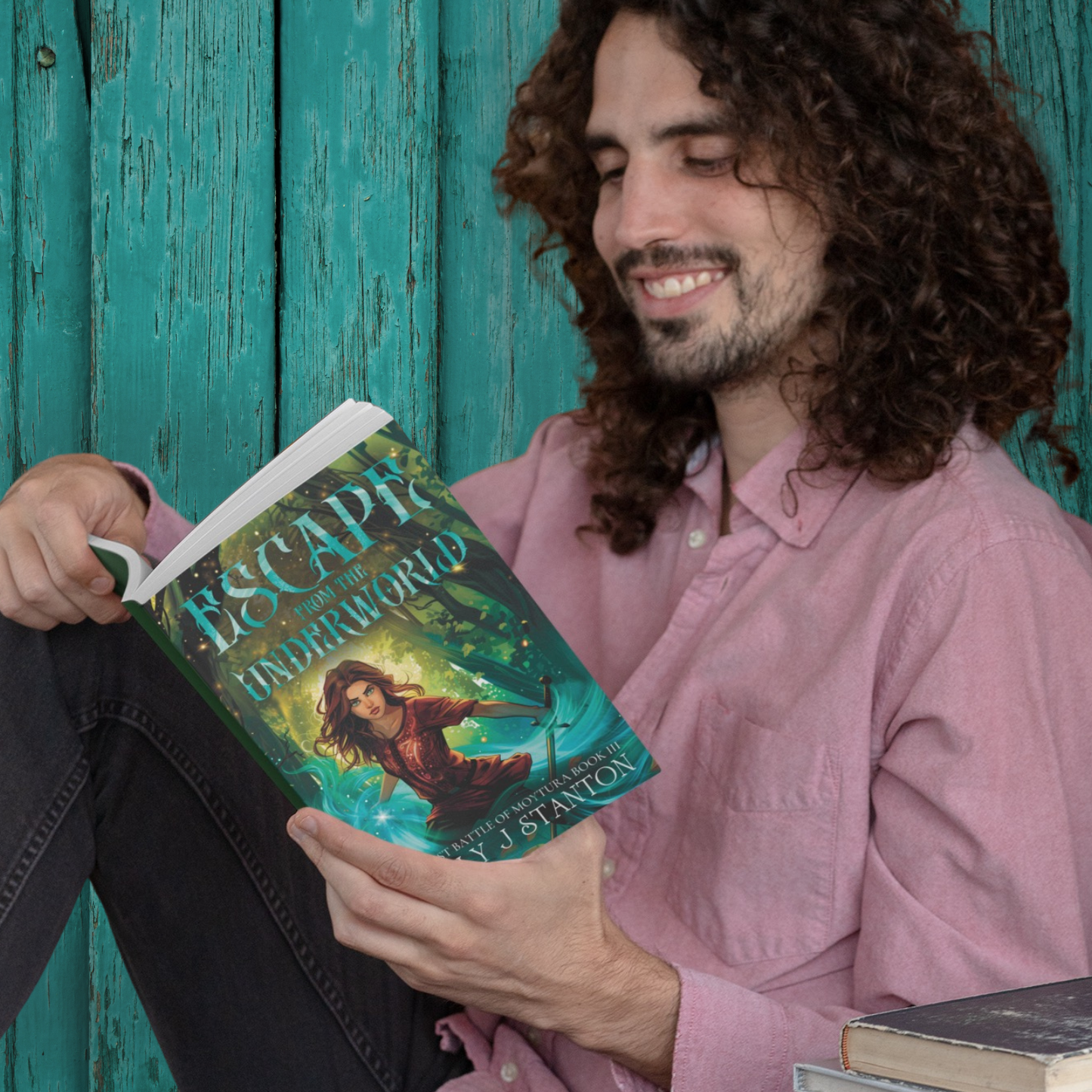 image of a young man with long hair and a beard reclining while reading the Escape from the Underworld paperback